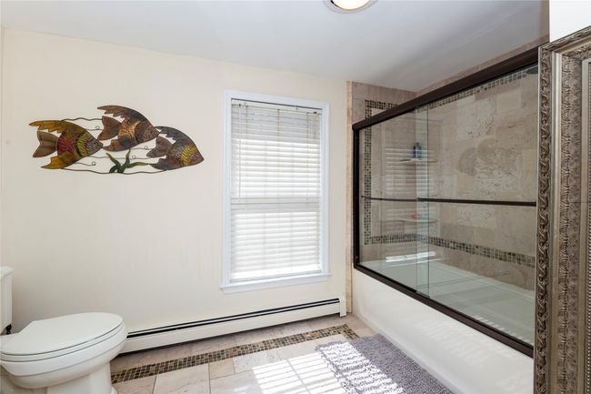 Hall Bathroom with toilet, a baseboard radiator, plenty of natural light, and combined bath / shower with glass door | Image 29