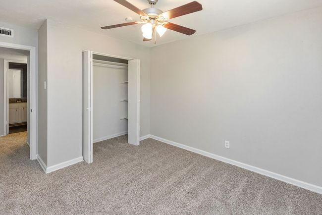 Unfurnished bedroom featuring a closet, a ceiling fan, baseboards, light colored carpet, and visible vents | Image 31