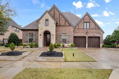 Tudor house with a front lawn and a garage | Image 1