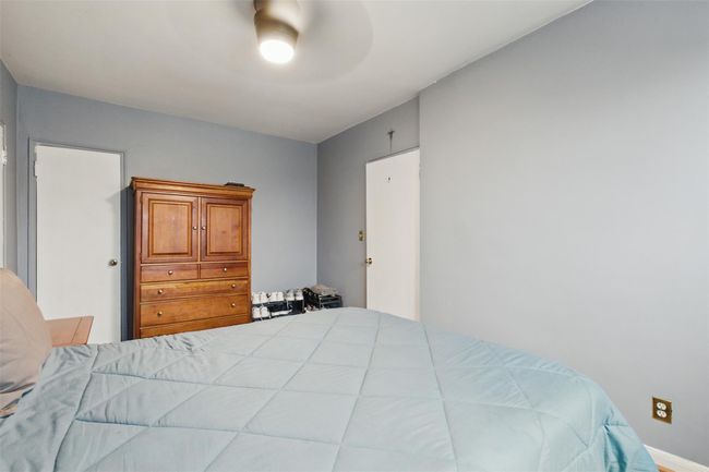Bright bedroom with ample closets and ceiling fan. | Image 13