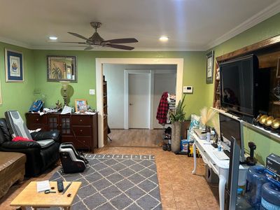 Living room with tile patterned floors, ceiling fan, and ornamental molding | Image 2