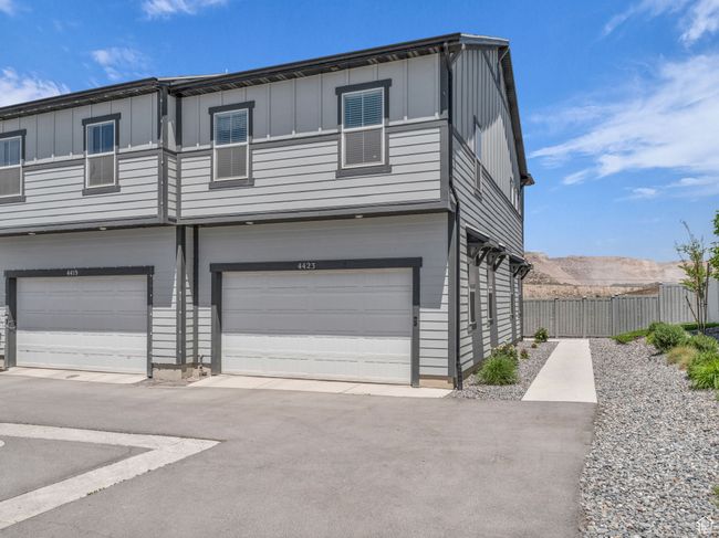 Townhome / multi-family property with an attached garage and board and batten siding | Image 27