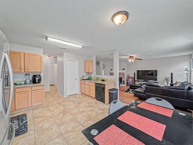 Kitchen featuring light brown cabinets, a sink, stainless steel fridge, and open floor plan | Image 9