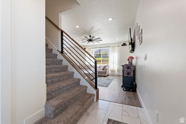 Stairway featuring a textured ceiling, baseboards, recessed lighting, marble finish floor, and ceiling fan | Image 10