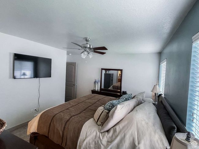 Bedroom featuring ceiling fan, carpet floors, and a textured ceiling | Image 10
