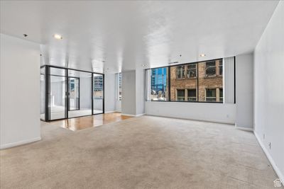 Unfurnished room featuring floor to ceiling windows and light colored carpet | Image 2