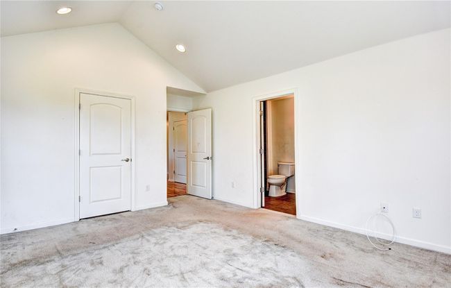 Primary bedroom with carpet, vaulted ceiling, baseboards, recessed lighting, and ensuite bath | Image 15
