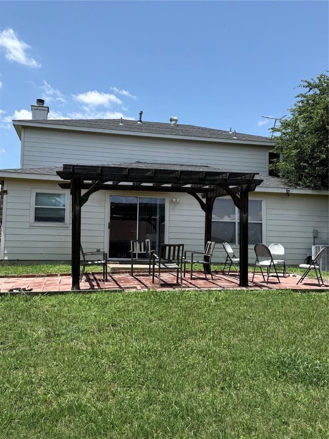 Back of house featuring a pergola, a patio area, a yard, and a chimney | Image 31