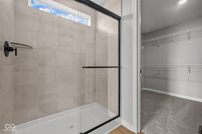full bath with baseboards, a walk in closet, and a shower stall | Image 22