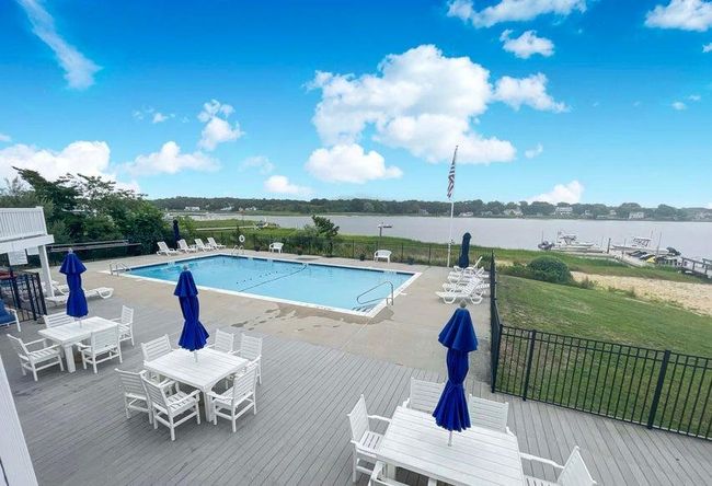 Community pool with a deck with water view, outdoor dining area, and a yard | Image 9