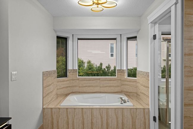 Bathroom with a textured ceiling and a garden tub | Image 25