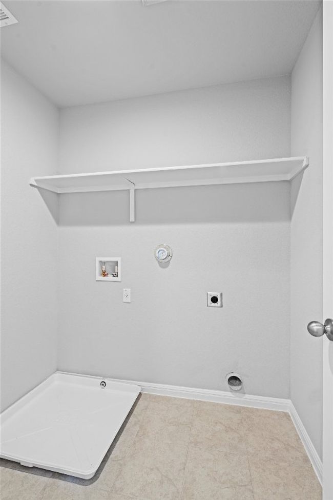 Washroom featuring gas dryer hookup, hookup for a washing machine, electric dryer hookup, and tile patterned floors | Image 31