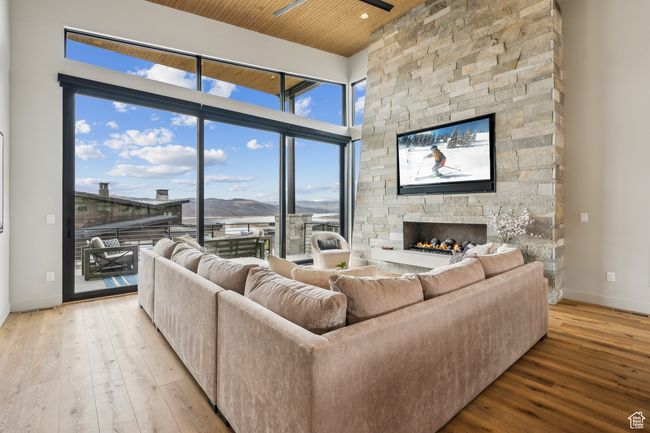 Living area with a fireplace, wood-type flooring, wood ceiling, and baseboards | Image 20