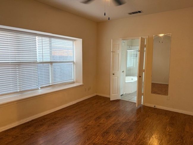 Unfurnished room featuring plenty of natural light, ceiling fan, and wood finished floors | Image 10