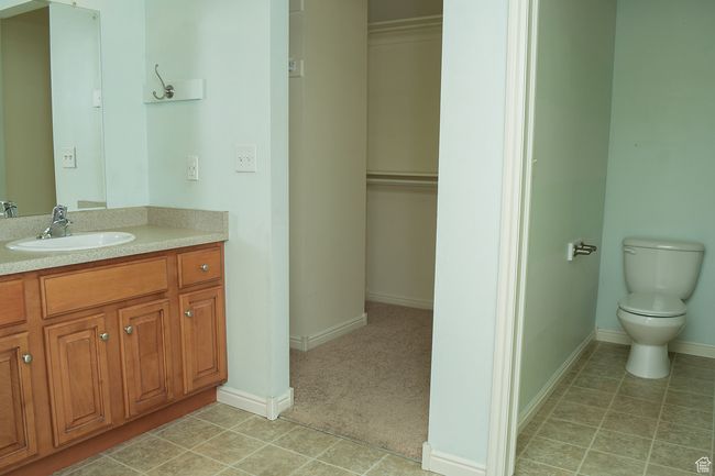 Bathroom with tile patterned flooring, vanity, baseboards, and toilet | Image 13