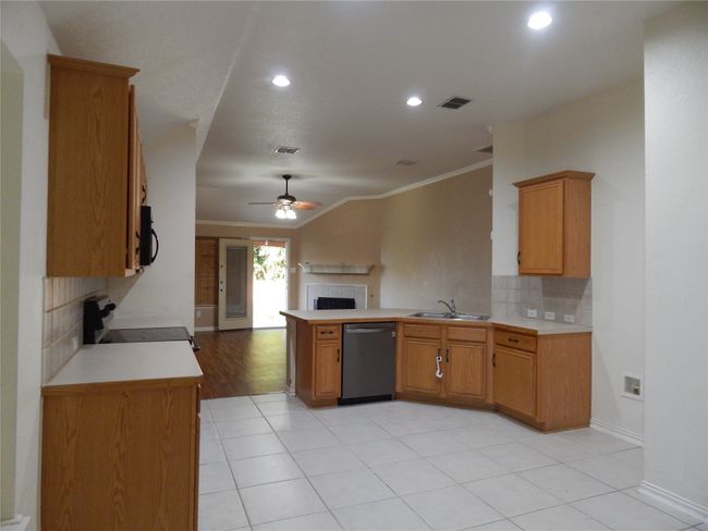 Kitchen with stainless steel dishwasher, electric range oven, open floor plan, ornamental molding, and a peninsula | Image 6