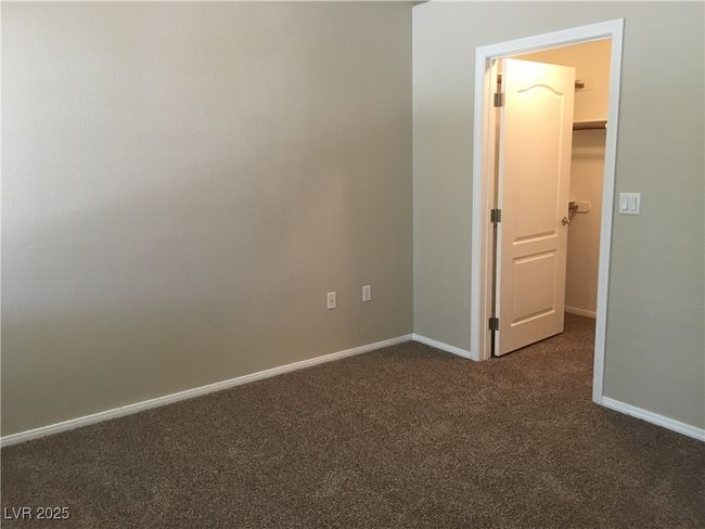 Spare room featuring dark colored carpet and baseboards | Image 13