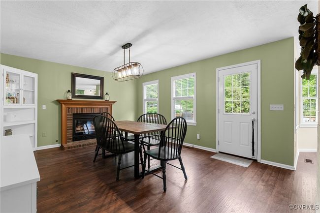 Dining space featuring a fireplace, plenty of natural light, and dark wood-style floors | Image 21