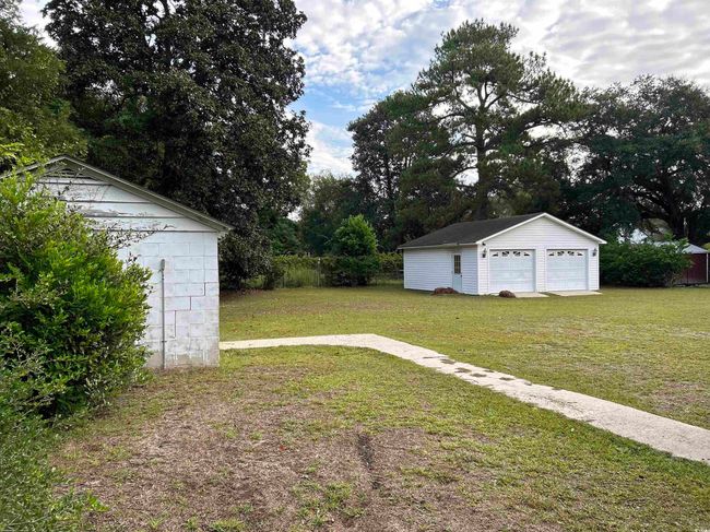 View of yard featuring a garage and an outdoor structure | Image 10
