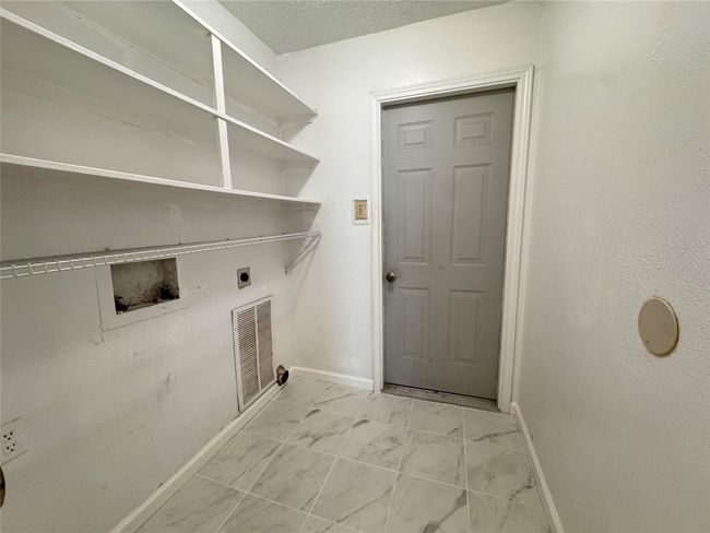 Washroom with electric dryer hookup, washer hookup, and light marble finish flooring | Image 12