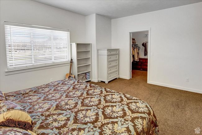 Bedroom featuring a walk in closet, carpet floors, and baseboards | Image 14