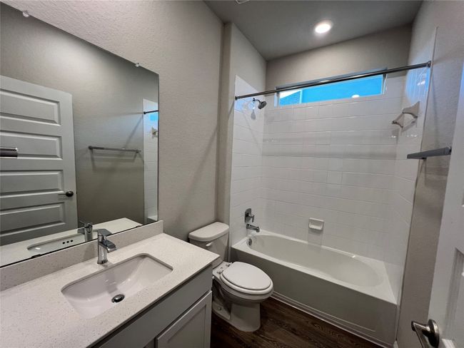 Full bathroom with wood finished floors, vanity, and washtub / shower combination | Image 9