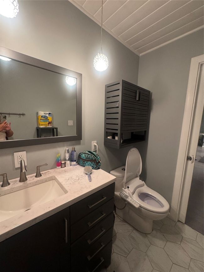 Bathroom featuring vanity, tile patterned floors, and lofted ceiling | Image 27