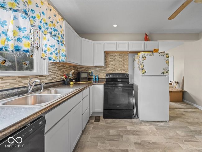 kitchen with black appliances, backsplash, white cabinets, recessed lighting, and dark countertops | Image 8