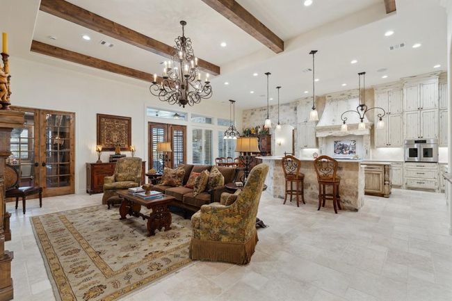 The large and openLiving Room featuresnatural travertine stone flooring. 13' beamed ceilings, a show stopping 60" scrolled iron 16-light chandelier, andrecessed lighting. Perfect for entertaining! | Image 9