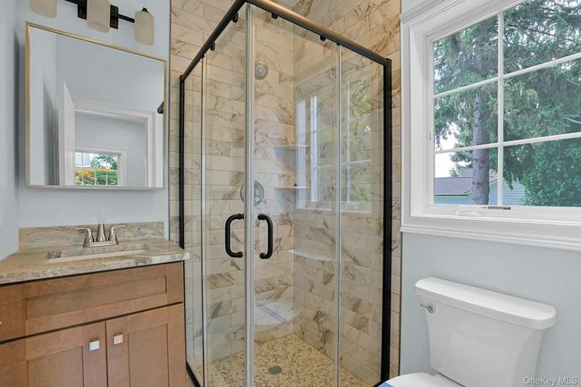 Bathroom with healthy amount of natural light, vanity, and a shower stall | Image 19
