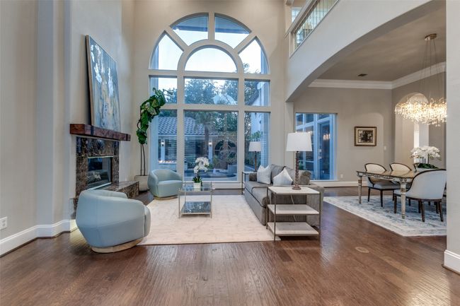 The formal living room creates an impressive first view into the home, with a massive arched window looking out to the beautiful back yard and an inviting fireplace. | Image 5