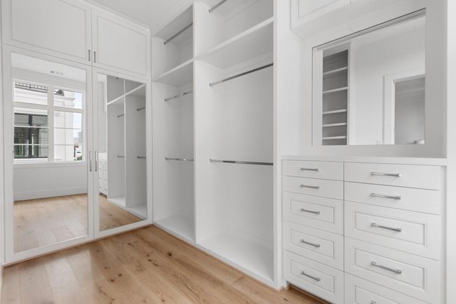 The spacious walk-in closet features elevated features such as furniture style cabinetry, adjustable shelves, a vanity area with specialized accessory storage, valet rods, and more | Image 27