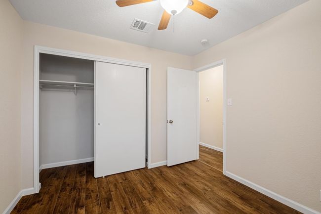 Unfurnished bedroom featuring wood finished floors, a closet, and ceiling fan | Image 13
