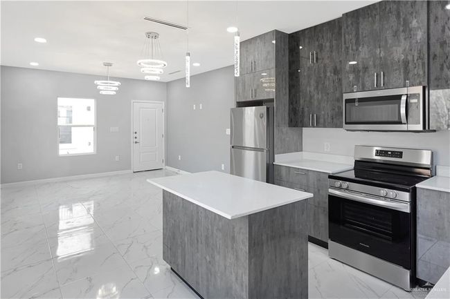 Kitchen featuring marble finish floor, modern cabinets, and stainless steel appliances | Image 7