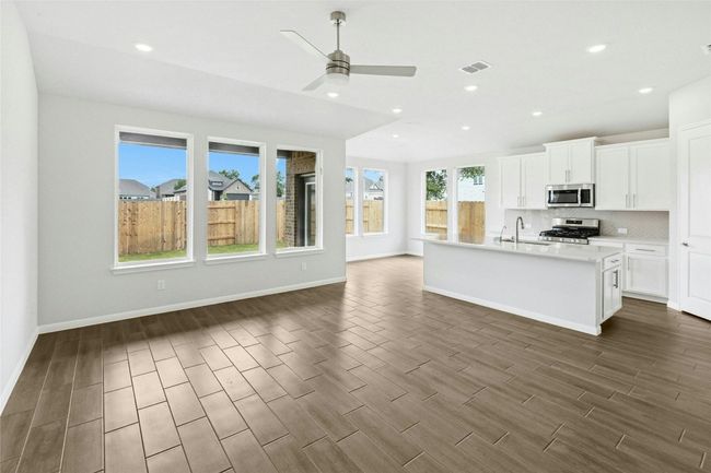 Kitchen with appliances with stainless steel finishes, open floor plan, dark wood-style floors, backsplash, and recessed lighting | Image 5