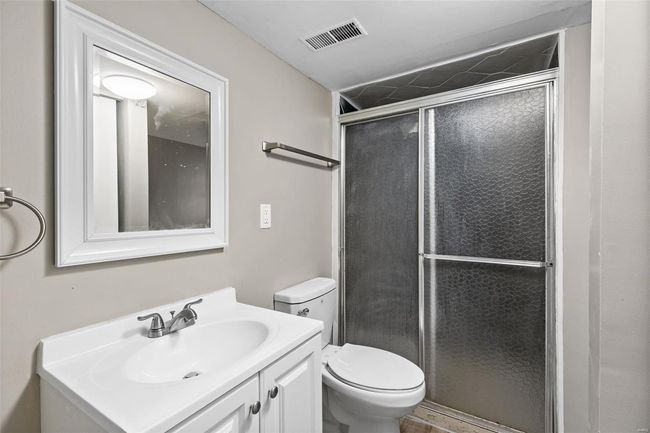 Bathroom with visible vents, toilet, vanity, and a stall shower | Image 27