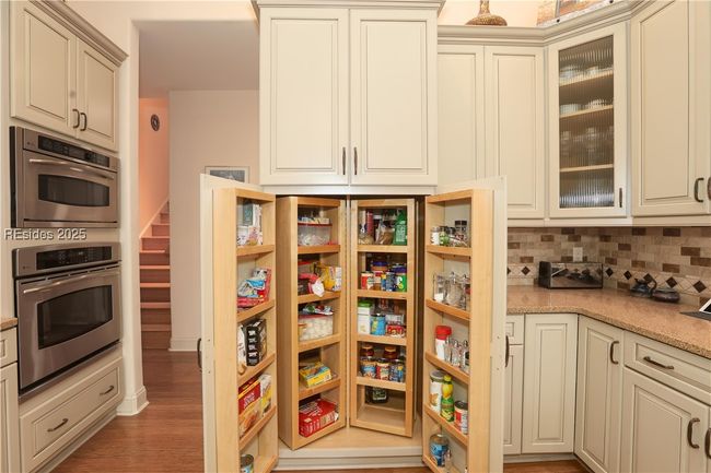 Wonderful built-in pantry with slide in storage. | Image 25