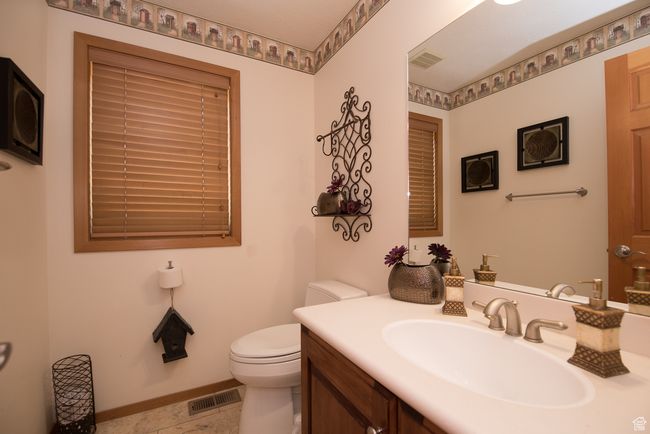 Bathroom featuring toilet, vanity, visible vents, and baseboards | Image 58