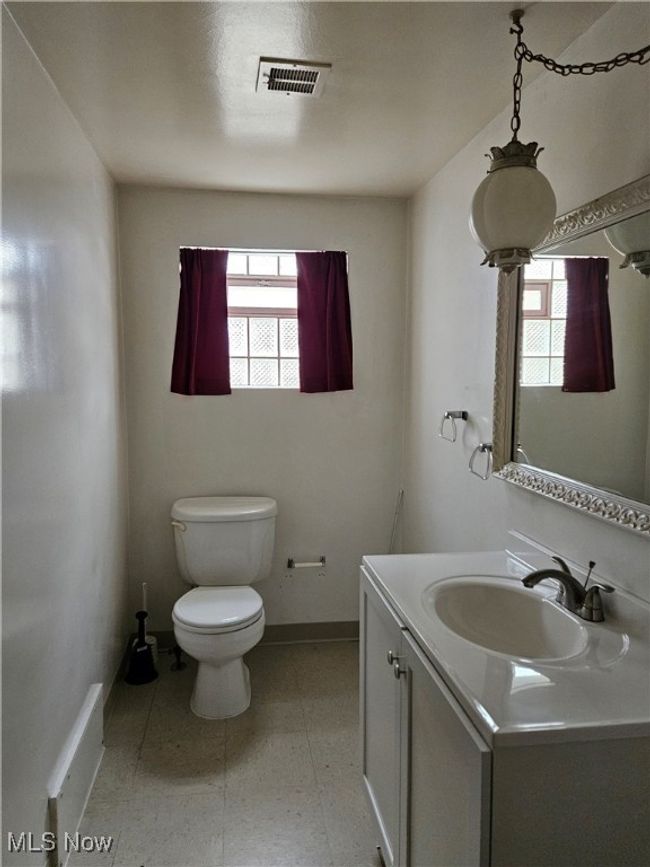 Bathroom featuring toilet, baseboards, a healthy amount of sunlight, and visible vents | Image 11