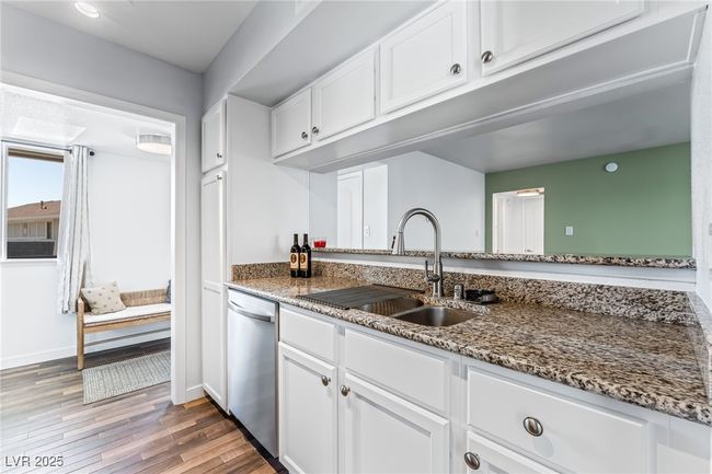 Kitchen featuring a sink, dishwasher, white cabinets, and stone countertops | Image 15