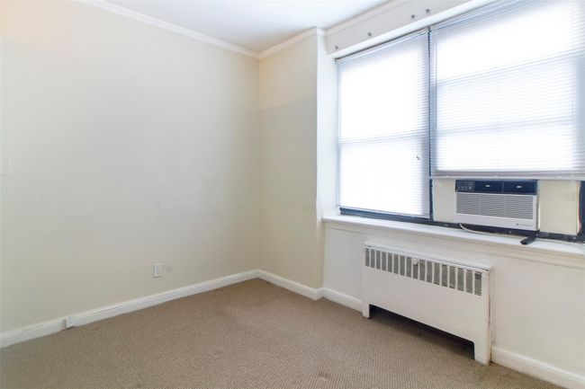 Bedroom Alcove featuring radiator, light colored carpet, and crown molding | Image 10