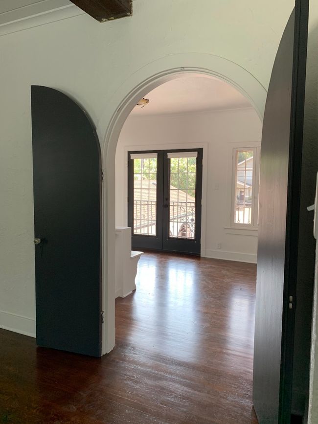 Foyer featuring arched walkways, french doors, and dark wood-style flooring | Image 5