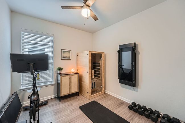 Workout room featuring light wood-style floors, baseboards, and a ceiling fan | Image 21