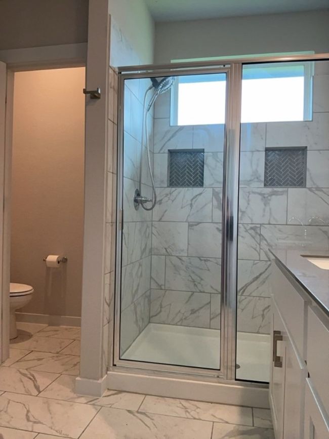 Bathroom with marble look tile flooring, vanity, and a shower stall | Image 20