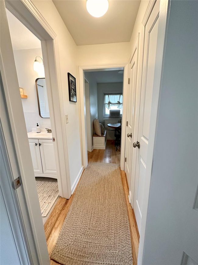Hall with light wood-style floors, an office area, and baseboards | Image 12