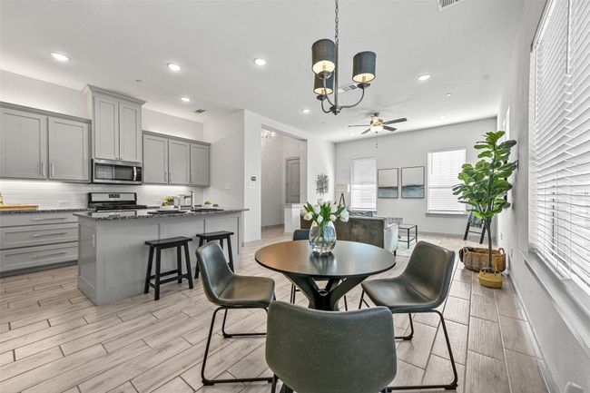 Dining area featuring light hardwood / wood-style floors and ceiling fan with notable chandelier | Image 15