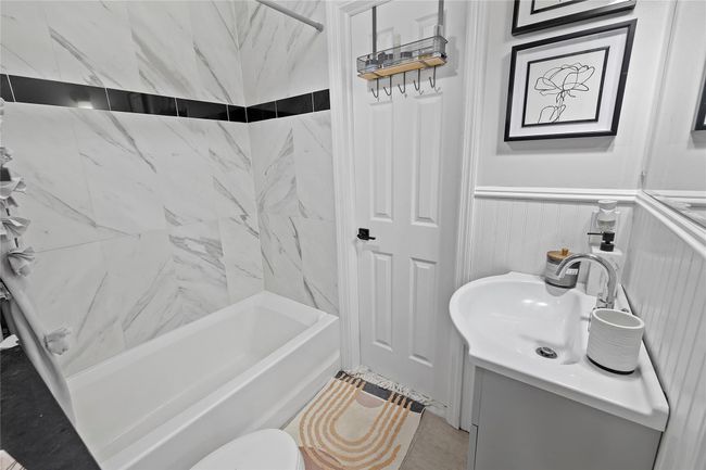 Full bathroom featuring toilet, tile patterned flooring, vanity, and shower / bathing tub combination | Image 10