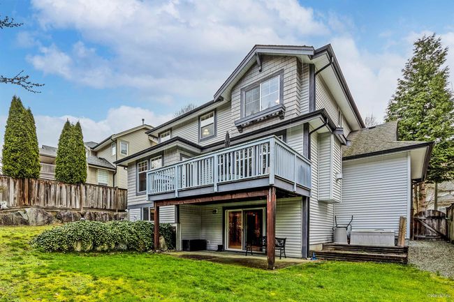 Rear view of house featuring a gate, fence, a wooden deck, a yard, and a patio area | Image 28