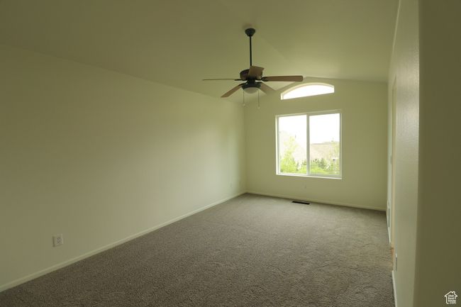 Unfurnished room featuring a ceiling fan, carpet, and lofted ceiling | Image 9