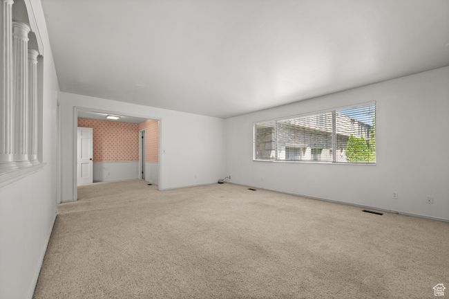 Empty room featuring wallpapered walls, light colored carpet, and baseboards | Image 13
